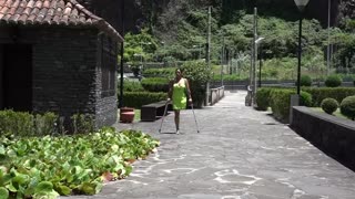 拄双拐单腿截肢女闲逛公园享受阳光
