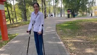 拄着双手拐单腿截肢女公园摆拍视频